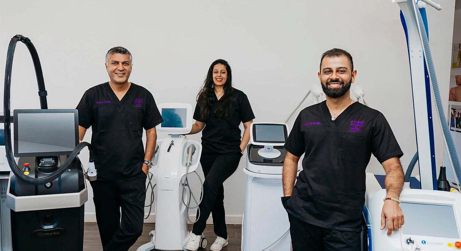 Medical professionals with aesthetic treatment equipment.